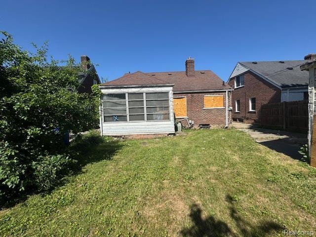 18460 Ferguson St, Detroit, MI 48235 - rear view of house with a chimney, brick siding, and a sunroom