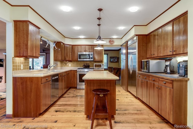 9601 Kier Rd, Holly, MI 48442 - kitchen with appliances with stainless steel finishes, a kitchen island, crown molding, light wood-type flooring, and decorative backsplash