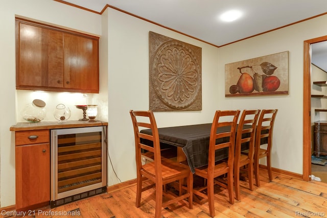 9601 Kier Rd, Holly, MI 48442 - dining room with beverage cooler, crown molding, light wood-type flooring, and a bar