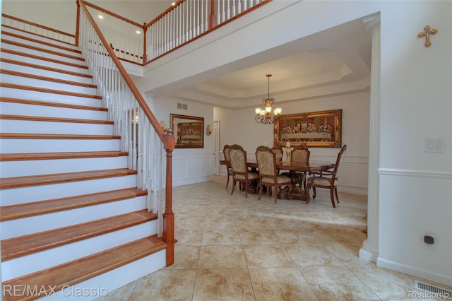 761 Nissen Ct, Wixom, MI 48393 - dining space featuring stairs, a decorative wall, a chandelier, and a raised ceiling