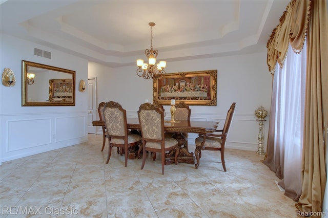 761 Nissen Ct, Wixom, MI 48393 - dining space with a raised ceiling, a chandelier, and a decorative wall