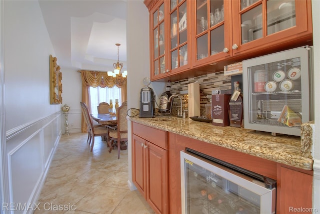 761 Nissen Ct, Wixom, MI 48393 - indoor bar featuring beverage cooler, a chandelier, a tray ceiling, wainscoting, and a decorative wall