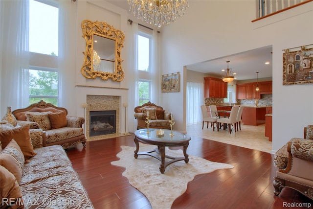 761 Nissen Ct, Wixom, MI 48393 - living area with a high ceiling, a chandelier, dark wood-type flooring, and a fireplace with flush hearth