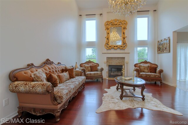 761 Nissen Ct, Wixom, MI 48393 - living area featuring a towering ceiling, a chandelier, plenty of natural light, a fireplace with flush hearth, and wood finished floors