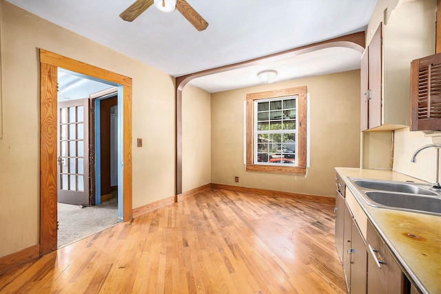 237 Holly St, Wyoming, MI 49548 - kitchen with arched walkways, light wood-style flooring, a ceiling fan, and light countertops