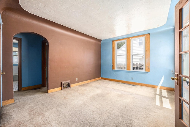 237 Holly St, Wyoming, MI 49548 - carpeted empty room with arched walkways and a textured ceiling