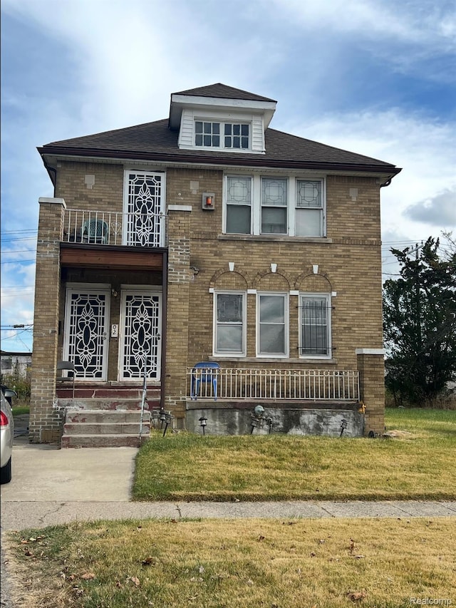 9900 Ohio St, Detroit, MI 48204 - view of front of home with a balcony, brick siding, a front yard, and covered porch