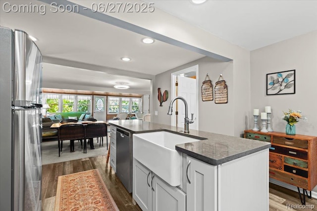 1500 Clark Lake Rd, Brighton, MI 48114 - kitchen with appliances with stainless steel finishes, dark wood finished floors, recessed lighting, a center island with sink, and dark stone countertops
