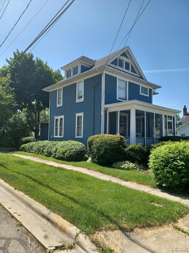 526 Comstock St, Adrian, MI 49221 - view of property exterior with a sunroom and a lawn
