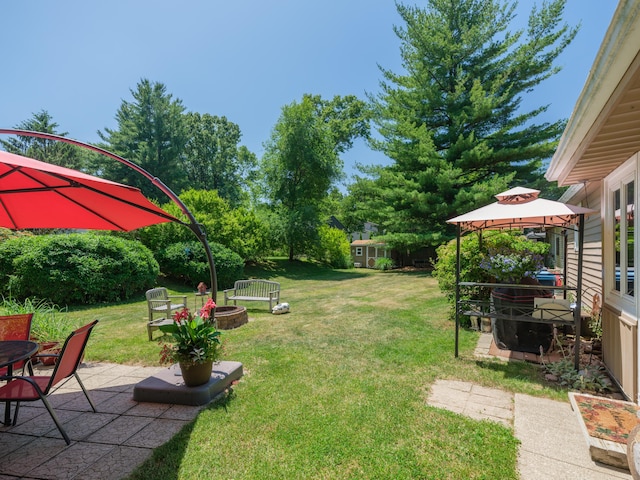 2805 Winchell Ave, Kalamazoo, MI 49008 - view of green lawn featuring a fire pit, a gazebo, and a patio area