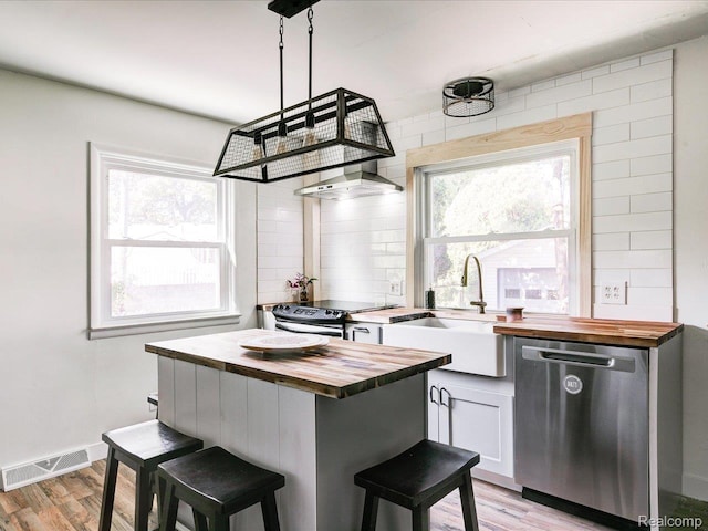 3107 Stone St, Port Huron, MI 48060 - kitchen featuring wooden counters, stainless steel appliances, light wood-style floors, a breakfast bar area, and white cabinetry