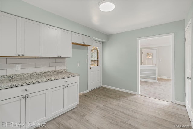 1413 Martha Ave, Burton, MI 48509 - kitchen with decorative backsplash, white cabinets, light wood-style floors, and light stone counters