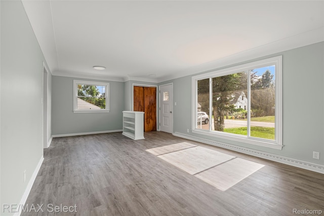 1413 Martha Ave, Burton, MI 48509 - unfurnished living room featuring wood finished floors and baseboard heating