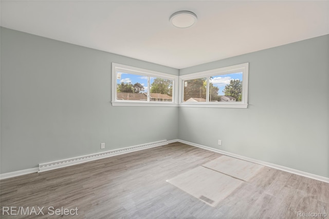 1413 Martha Ave, Burton, MI 48509 - spare room with a baseboard radiator and wood finished floors