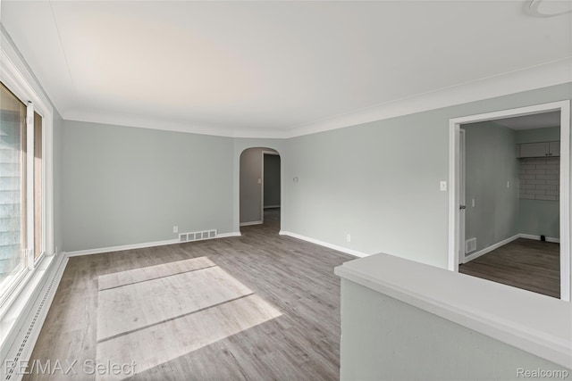 1413 Martha Ave, Burton, MI 48509 - spare room featuring arched walkways, wood finished floors, and ornamental molding