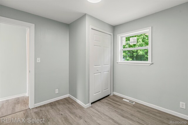 1413 Martha Ave, Burton, MI 48509 - unfurnished bedroom featuring light wood-style floors and a closet