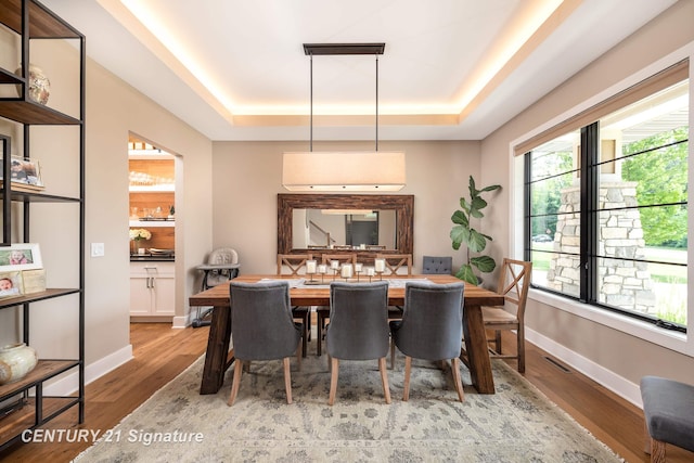2985 E Iron Woods Pass, Midland, MI 48642 - dining area featuring a tray ceiling and wood finished floors