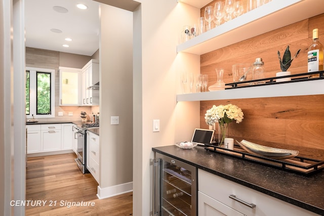 2985 E Iron Woods Pass, Midland, MI 48642 - indoor dry bar with wine cooler, stainless steel gas range, light wood-style flooring, recessed lighting, and backsplash