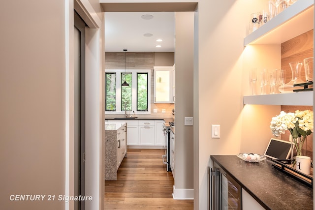 2985 E Iron Woods Pass, Midland, MI 48642 - corridor with wine cooler, light wood-style flooring, and recessed lighting
