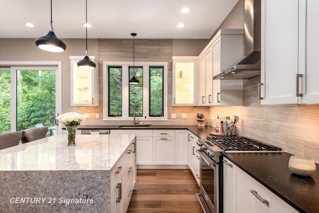 2985 E Iron Woods Pass, Midland, MI 48642 - kitchen with high end range, wall chimney exhaust hood, dark stone countertops, white cabinetry, and recessed lighting