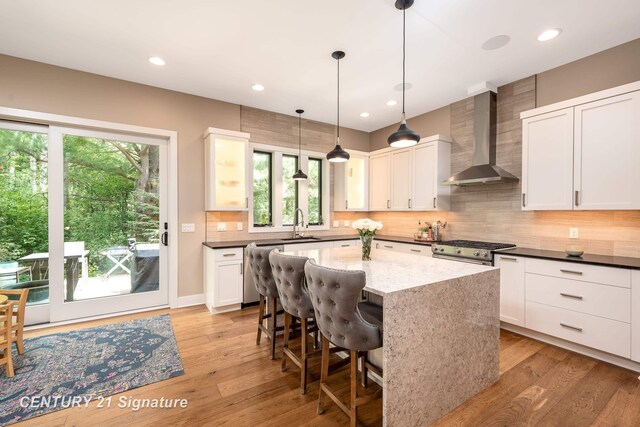 2985 E Iron Woods Pass, Midland, MI 48642 - kitchen with wall chimney exhaust hood, healthy amount of natural light, white cabinetry, and recessed lighting