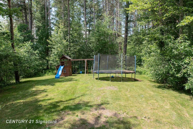 2985 E Iron Woods Pass, Midland, MI 48642 - view of green lawn featuring a trampoline, a playground, and a forest view