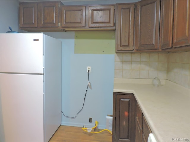 239 W Cornell Ave, Pontiac, MI 48340 - kitchen with freestanding refrigerator, tasteful backsplash, light countertops, and wood finished floors