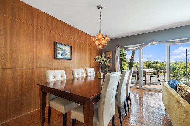 2507 Riverwood Ter, Saint Joseph, MI 49085 - dining area with healthy amount of natural light, a chandelier, wooden walls, and hardwood / wood-style flooring