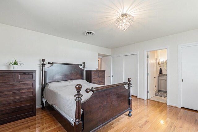 2507 Riverwood Ter, Saint Joseph, MI 49085 - bedroom featuring light wood finished floors, ensuite bath, and a chandelier