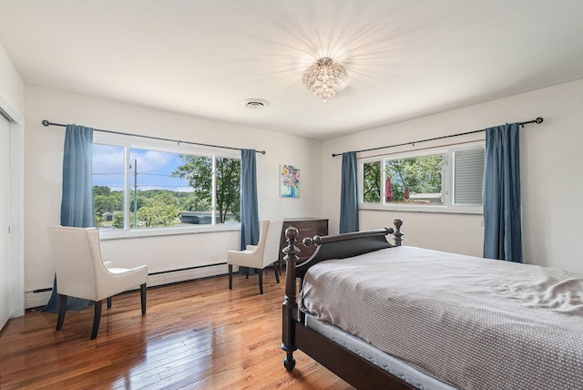 2507 Riverwood Ter, Saint Joseph, MI 49085 - bedroom featuring multiple windows, baseboard heating, light wood finished floors, and a baseboard heating unit