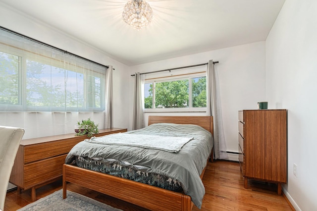2507 Riverwood Ter, Saint Joseph, MI 49085 - bedroom featuring light wood-style flooring, a baseboard heating unit, and a chandelier