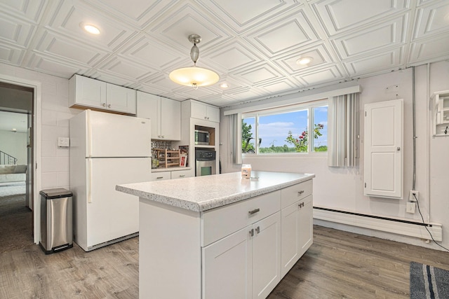 2507 Riverwood Ter, Saint Joseph, MI 49085 - kitchen featuring stainless steel appliances, an ornate ceiling, light wood-style floors, white cabinetry, and baseboard heating