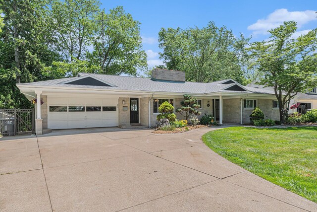 2507 Riverwood Ter, Saint Joseph, MI 49085 - single story home featuring concrete driveway, a garage, a chimney, a shingled roof, and brick siding