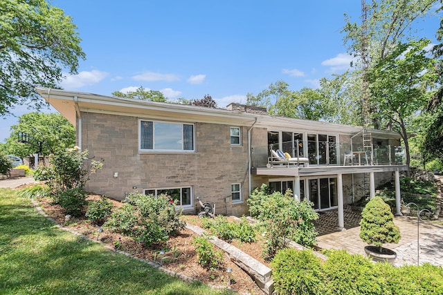 2507 Riverwood Ter, Saint Joseph, MI 49085 - rear view of house with a patio, a sunroom, stone siding, and a balcony