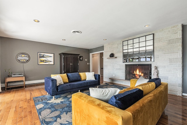 2507 Riverwood Ter, Saint Joseph, MI 49085 - living area with a baseboard radiator, a stone fireplace, wood finished floors, and recessed lighting