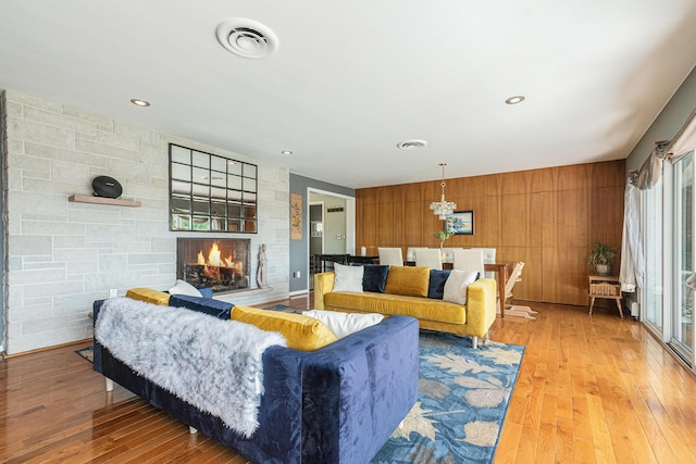 2507 Riverwood Ter, Saint Joseph, MI 49085 - living area with wood-type flooring, a fireplace, wood walls, recessed lighting, and a chandelier