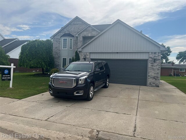 36339 Cecilia Dr, Sterling Heights, MI 48312 - traditional-style house with driveway, brick siding, a front yard, and a garage