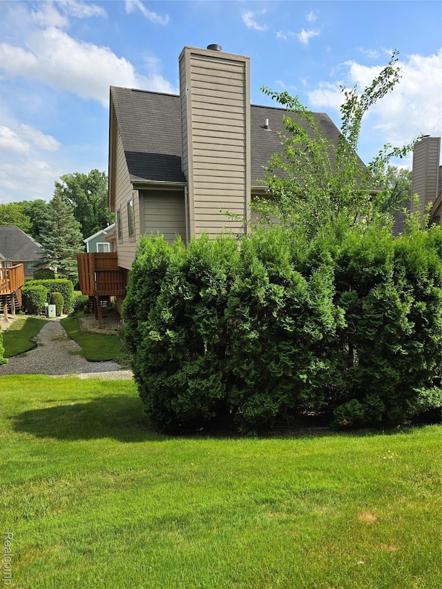 5605 Northcrest Xing, Clarkston, MI 48346 - view of home's exterior with a shingled roof, a chimney, a lawn, and a deck