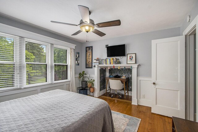 2313 S Westnedge Ave, Kalamazoo, MI 49008 - bedroom with wood-type flooring, wainscoting, and ceiling fan
