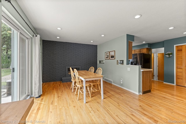 17276 Midway Ave, Allen Park, MI 48101 - dining room featuring recessed lighting, light wood finished floors, brick wall, and a brick fireplace