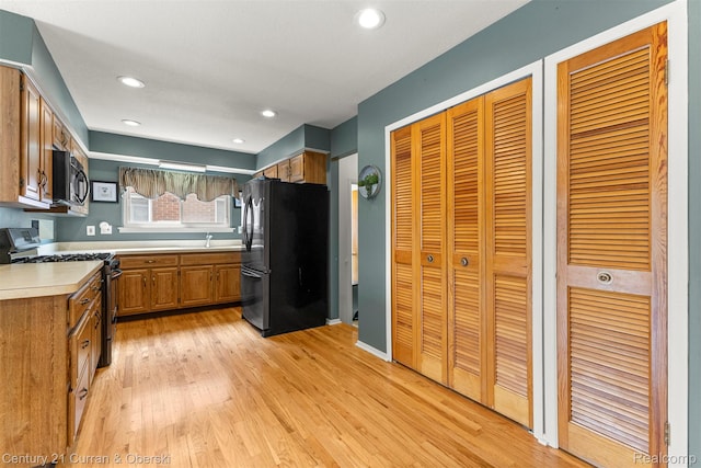 17276 Midway Ave, Allen Park, MI 48101 - kitchen featuring freestanding refrigerator, gas range, brown cabinets, light wood-style flooring, and light countertops