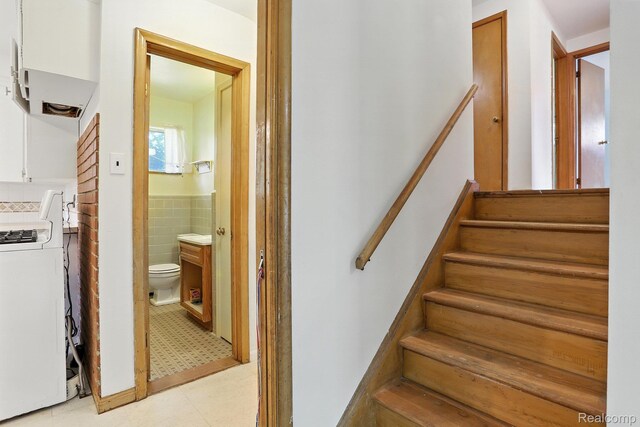 45411 Sterritt St, Utica, MI 48317 - staircase featuring washer / dryer, tile walls, and wainscoting