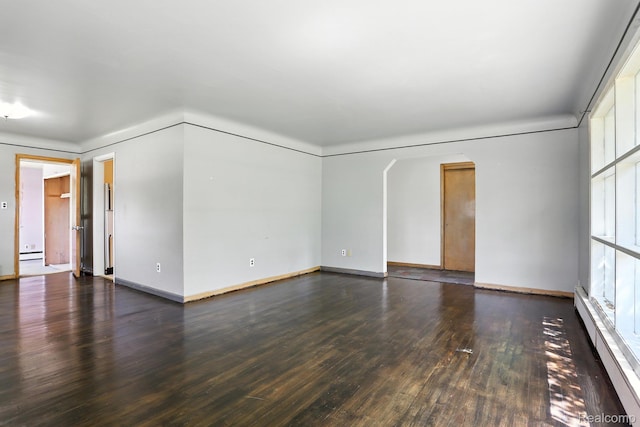 45411 Sterritt St, Utica, MI 48317 - empty room featuring baseboard heating, wood-type flooring, arched walkways, and a baseboard heating unit