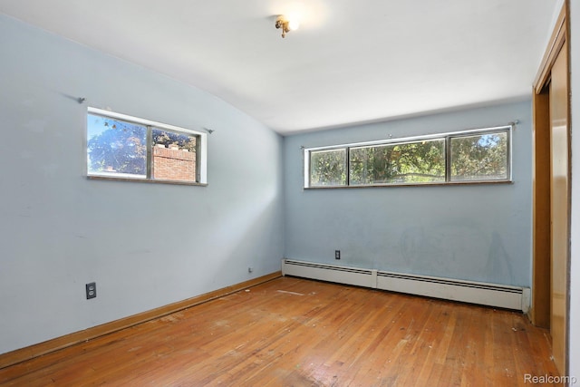 45411 Sterritt St, Utica, MI 48317 - empty room featuring baseboard heating, hardwood / wood-style flooring, and lofted ceiling