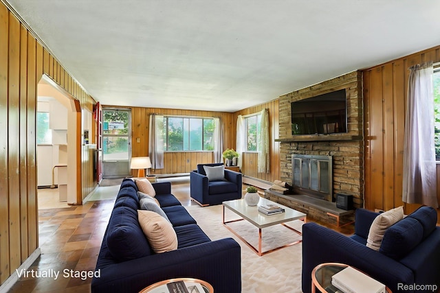 45411 Sterritt St, Utica, MI 48317 - living area with wooden walls, a baseboard heating unit, plenty of natural light, and a stone fireplace