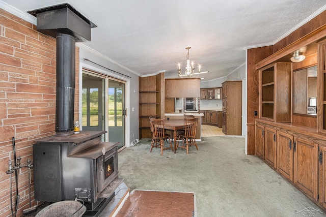 11816 Morton Rd, Manistee, MI 49660 - dining area featuring a wood stove, ornamental molding, a chandelier, and light colored carpet