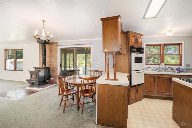 11816 Morton Rd, Manistee, MI 49660 - kitchen featuring white double oven, brown cabinetry, light countertops, plenty of natural light, and crown molding