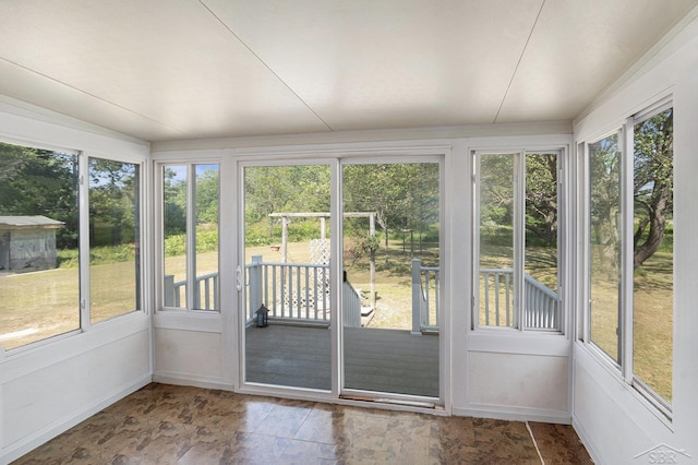 11816 Morton Rd, Manistee, MI 49660 - unfurnished sunroom featuring baseboards and stone finish flooring