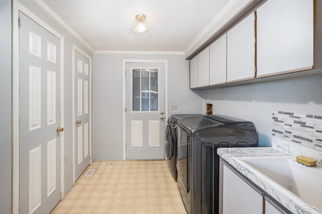 11816 Morton Rd, Manistee, MI 49660 - washroom with washing machine and dryer, ornamental molding, cabinet space, and light flooring