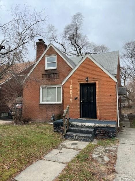 16611 Cruse St, Detroit, MI 48235 - view of front of home with brick siding, a chimney, and a front lawn